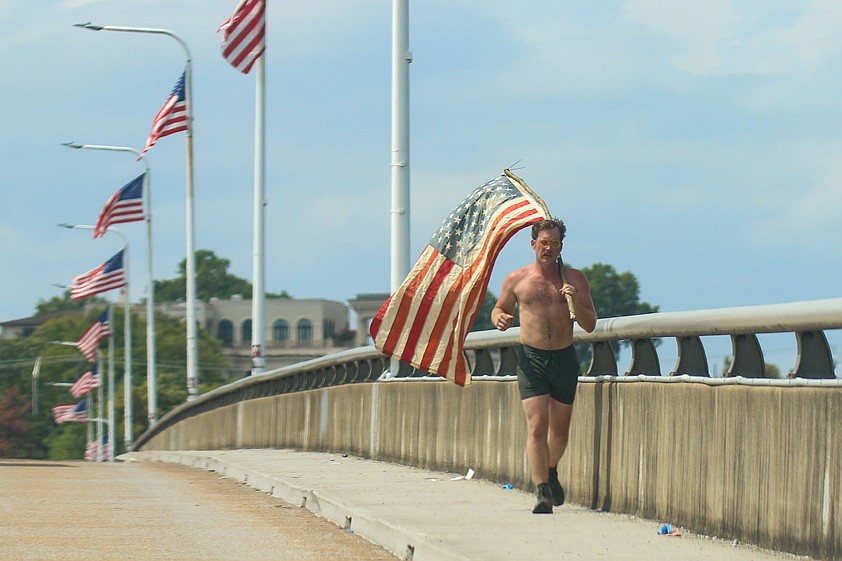 Staff photo by Olivia Ross / Joshua Kapellusch continues his run to honor the Fallen Five on Tuesday. Kapellusch ran from Tennessee Riverpark to Coolidge Park while carrying the American flag.
